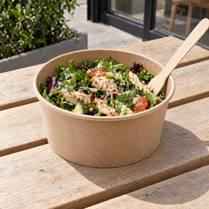 Chicken salad in a kraft salad bowl on a bench outside a cafe