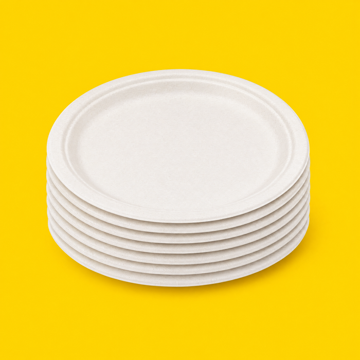 Stack of white bagasse 9 inch round plates, on yellow