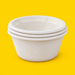 Stack of natural bagasse round bowls 1000ml, on yellow