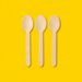 Three birchwood wooden spoons, on yellow