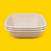 Stack of natural bagasse square bowls 1000ml, on yellow