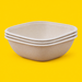 Stack of natural bagasse square bowls 1500ml, on yellow