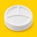 Stack of white bagasse 10 inch 3-compartment plates, on yellow