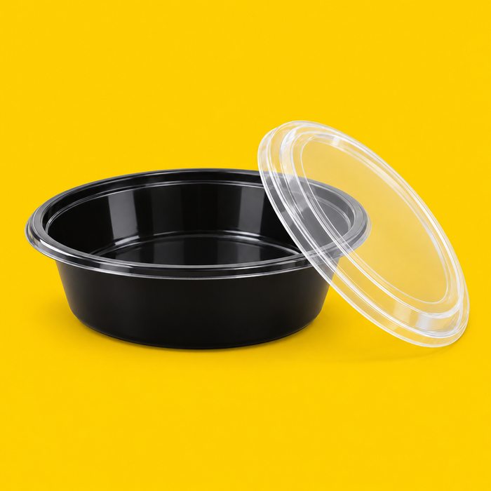 Black 9 inch round food container with its clear lid, on yellow