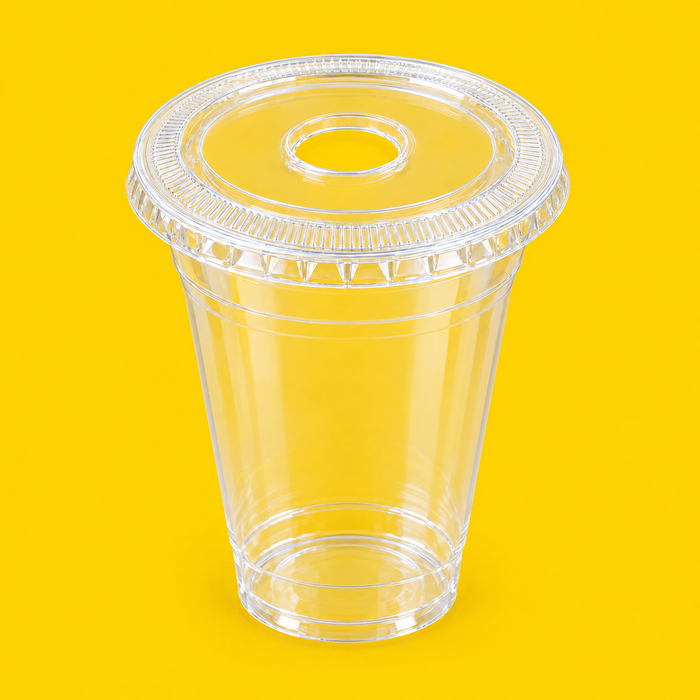 Clear PET flat lid with large straw hole fitted on a 12oz cold cup, on yellow