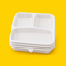 Stack of white 3-compartment bento box bases, on yellow