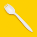 Close-up of a white cornstarch spork, on yellow